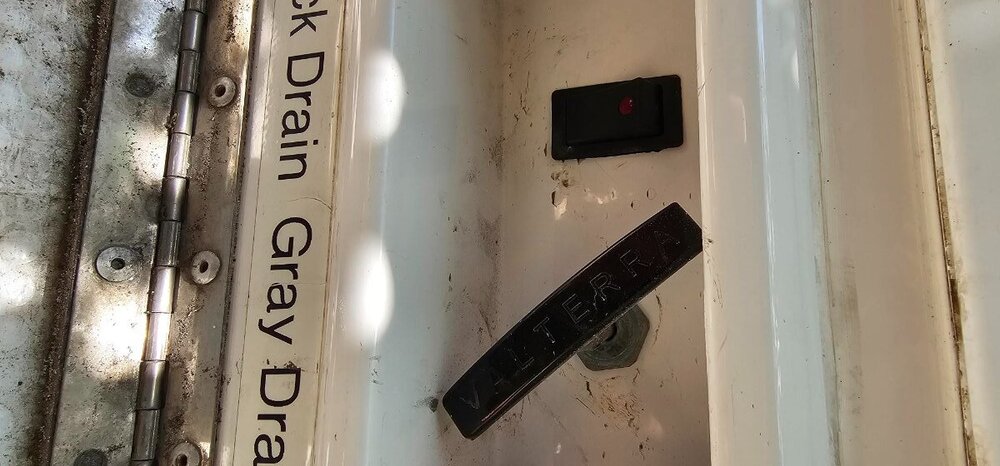 Water pump drain mounted where decommissioned where the black tank valve handle was.